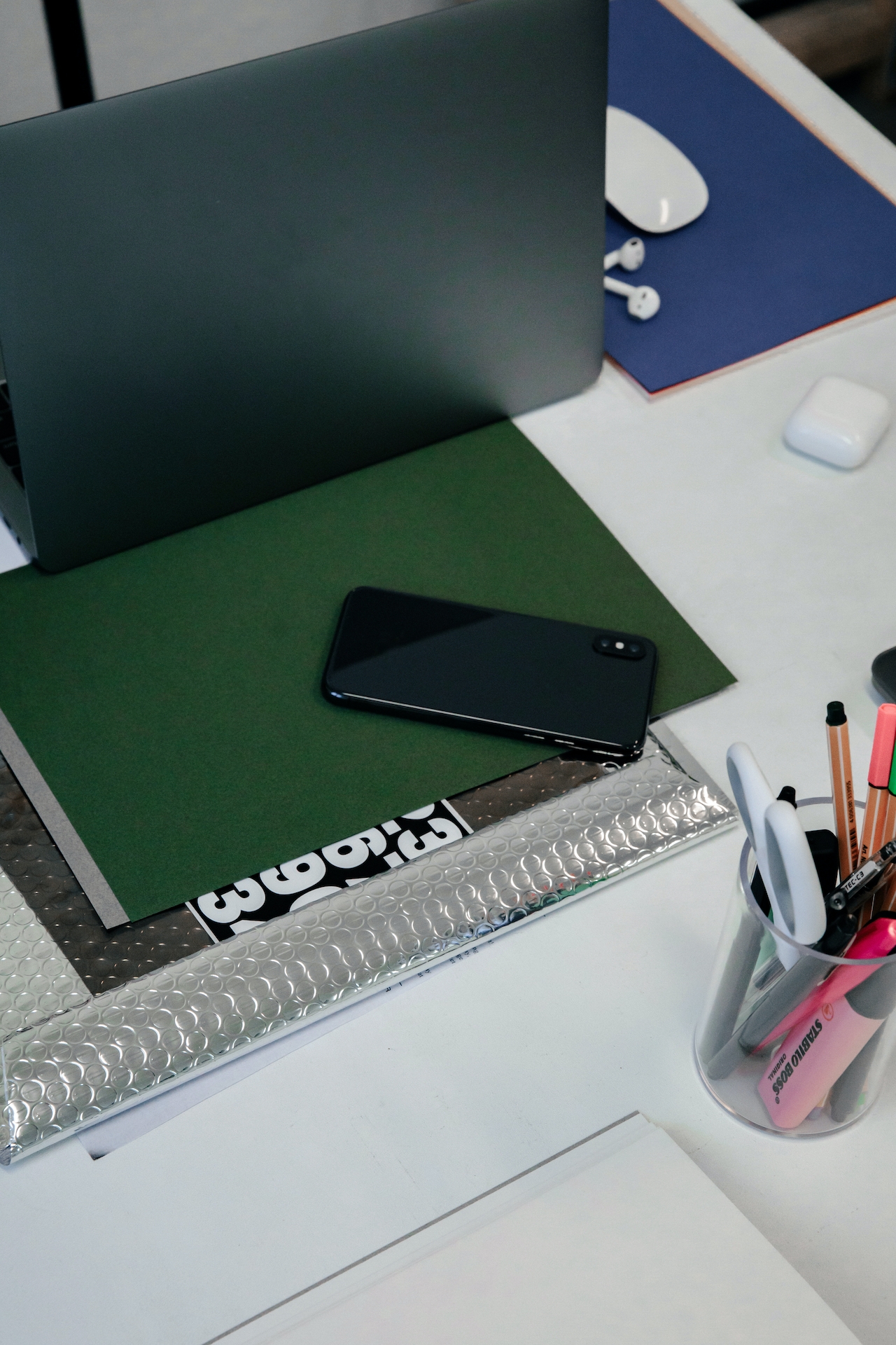 photo of iphone on top of a green folder in an office